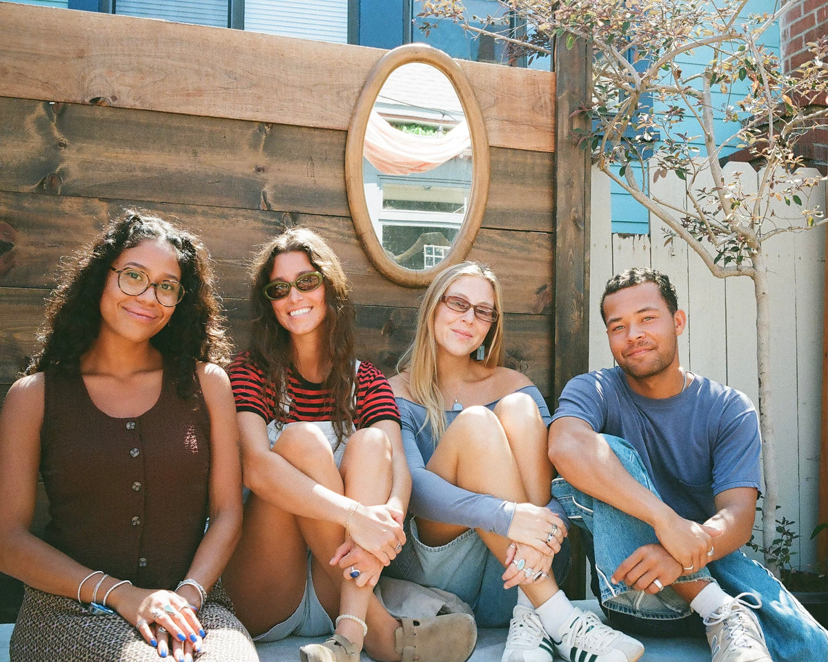 Friends sitting together on a bench at a Color Magic event