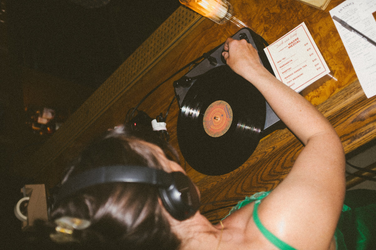 Hands cueing a vinyl record on a turntable