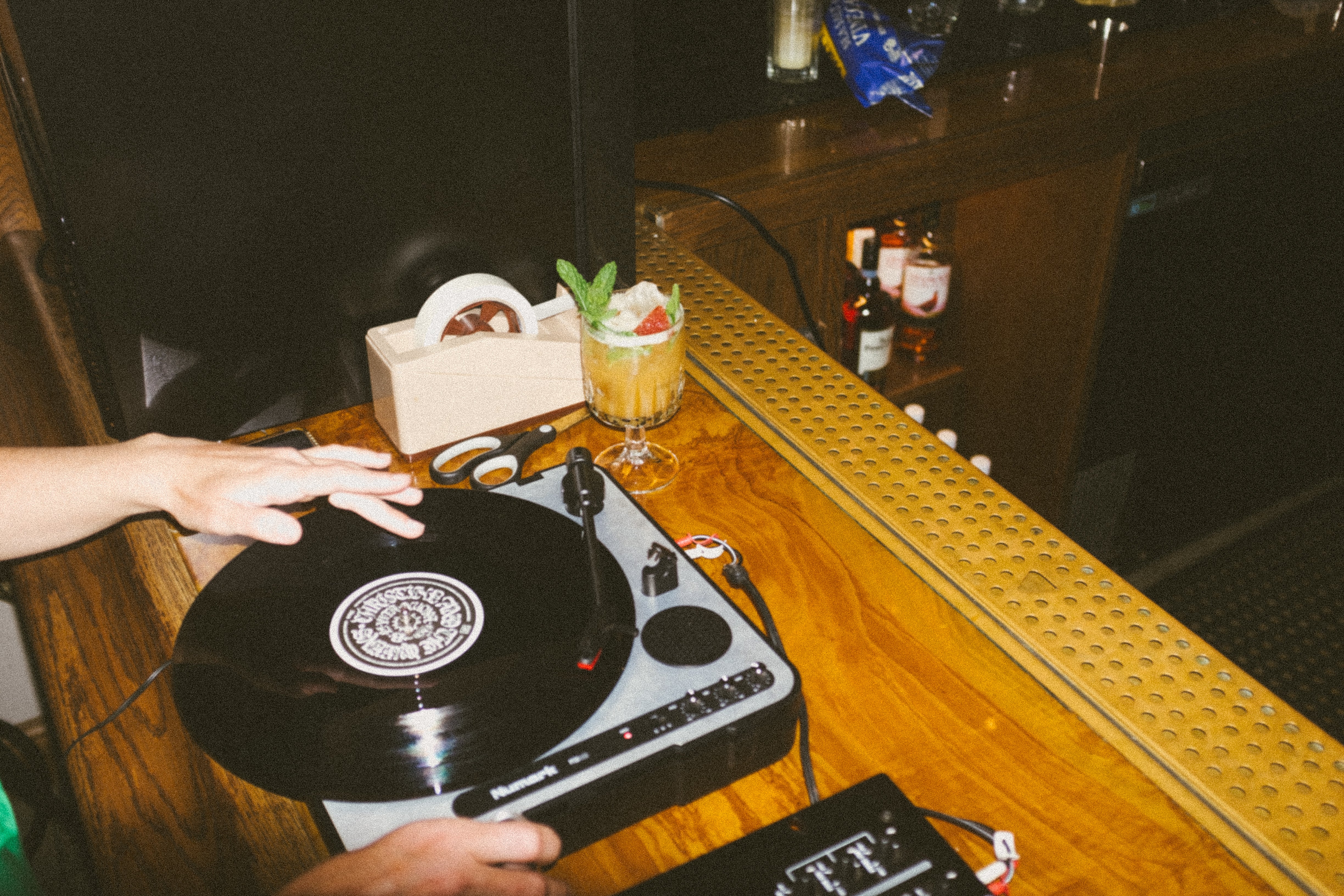 Turntables and mixer set up on a wooden bar