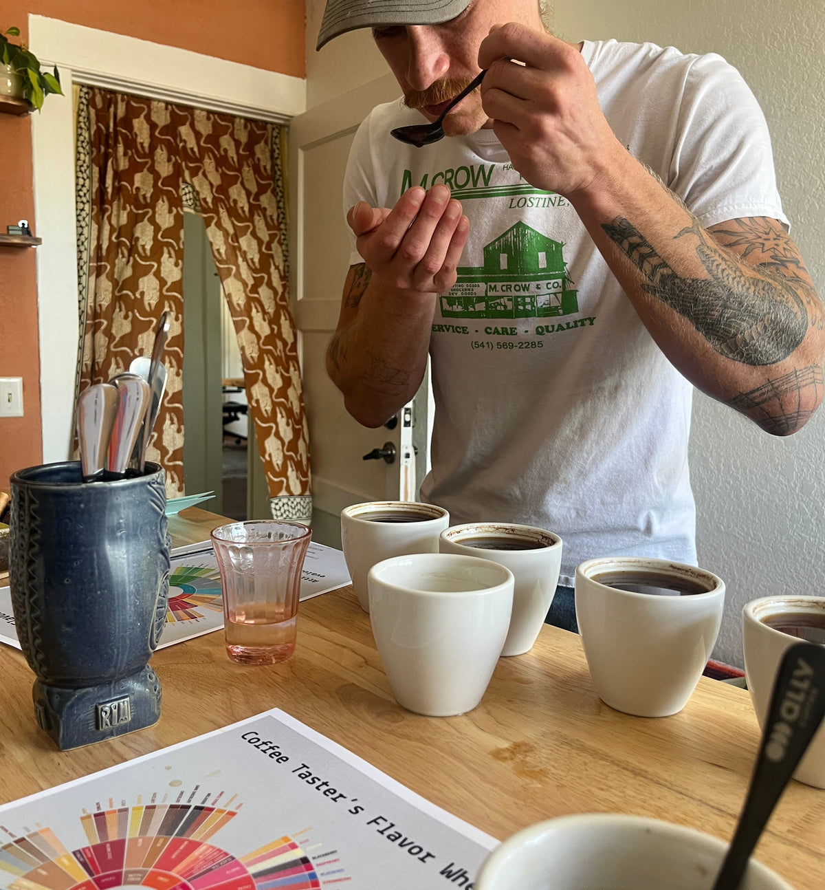 Guest tasting coffee at the cupping table in the studio